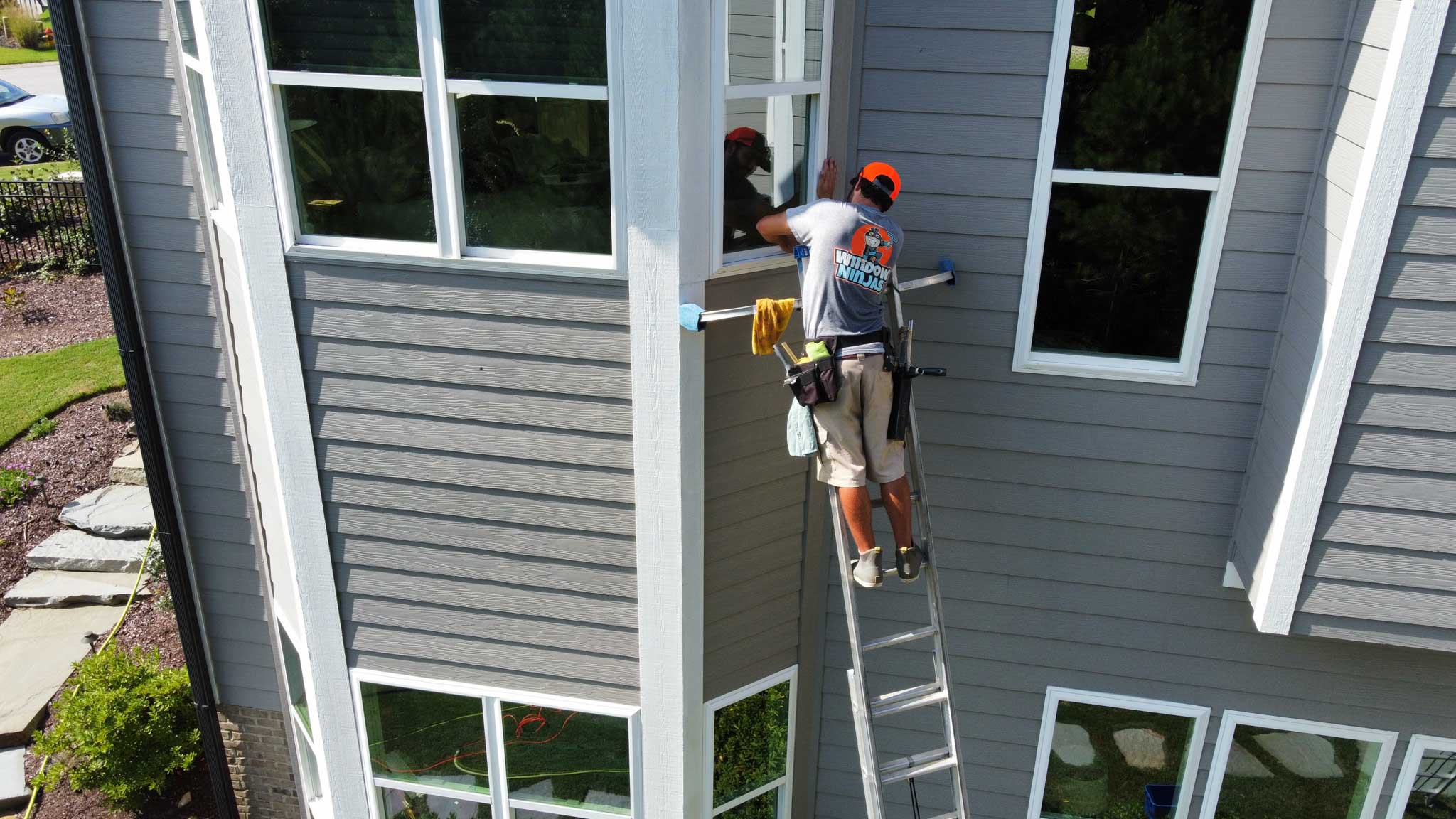 A Window Ninjas Myrtle Beach technician cleaning high windows - contact us to learn more about our glass cleaning services!